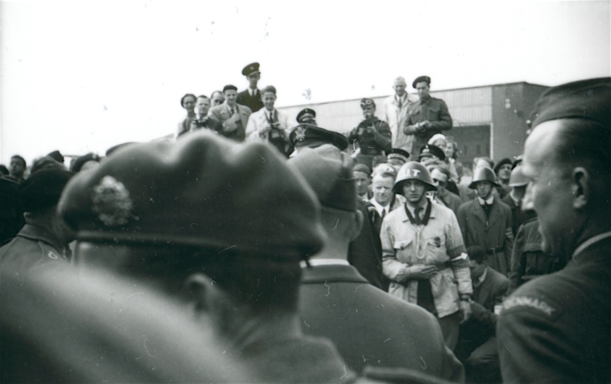 People gathering in front of Hangar B to see Montgomery. Flt Lt Vagn Christensen walks into the frame from the far right wearing his “DENMARK” shoulder flash (Museum of Danish Resistance).