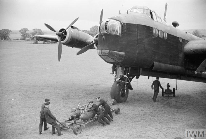 A Stirling I of No 218 (Gold Coast) Squadron being bombed-up at Downham Market, Norfolk, in the summer of 1942, soon after the airfield, which was a satellite of Marham, opened. The bomb train has arrived at the Stirling's dispersal and a pair of 1,000lb GP bombs are about to be pushed into position beneath the aircraft. © IWM (D 8972)
