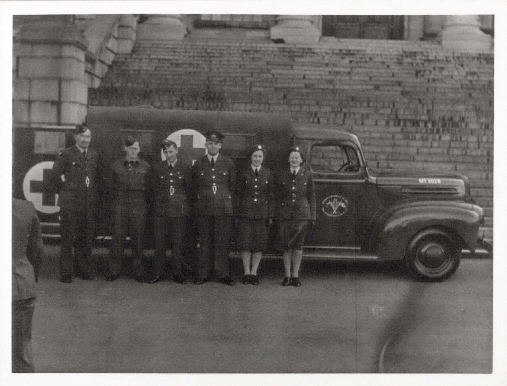 Danish volunteers in front of the ambulance. From left to right: Peter Hansen, Kaj Olaf Mortensen, Knud Graae, Arne Leth Møller, ambulance driver Mrs. Andersen, and Mrs. Audrey Nina Haderup. (Danish Royal Library)