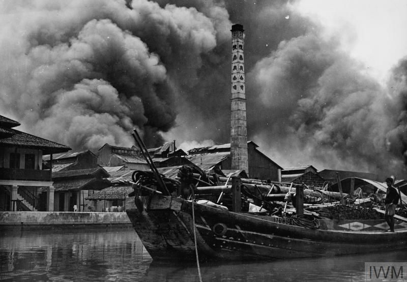 Poul Henrichsen and the other cadets of the last course in Singapore attended the Flying Training School at a most dramatic time. The photo show smoke billows from bombed buildings on Kallang airfield after a Japanese air raid, February 1942 (© IWM HU 69968)